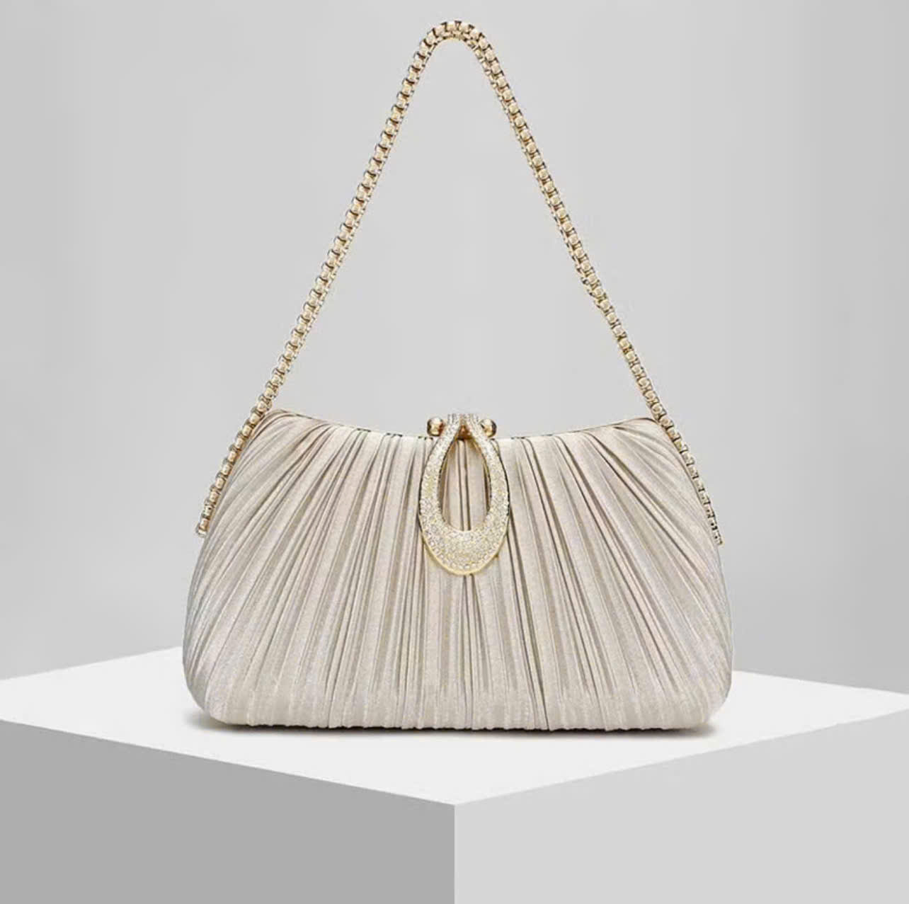 Premium women's party handbag featuring a pleated design and sparkling stone embellishments.