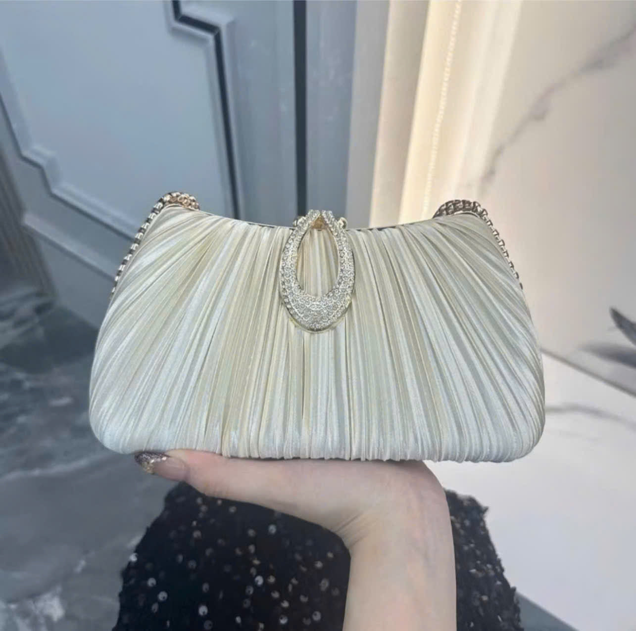 Premium women's party handbag featuring a pleated design and sparkling stone embellishments.