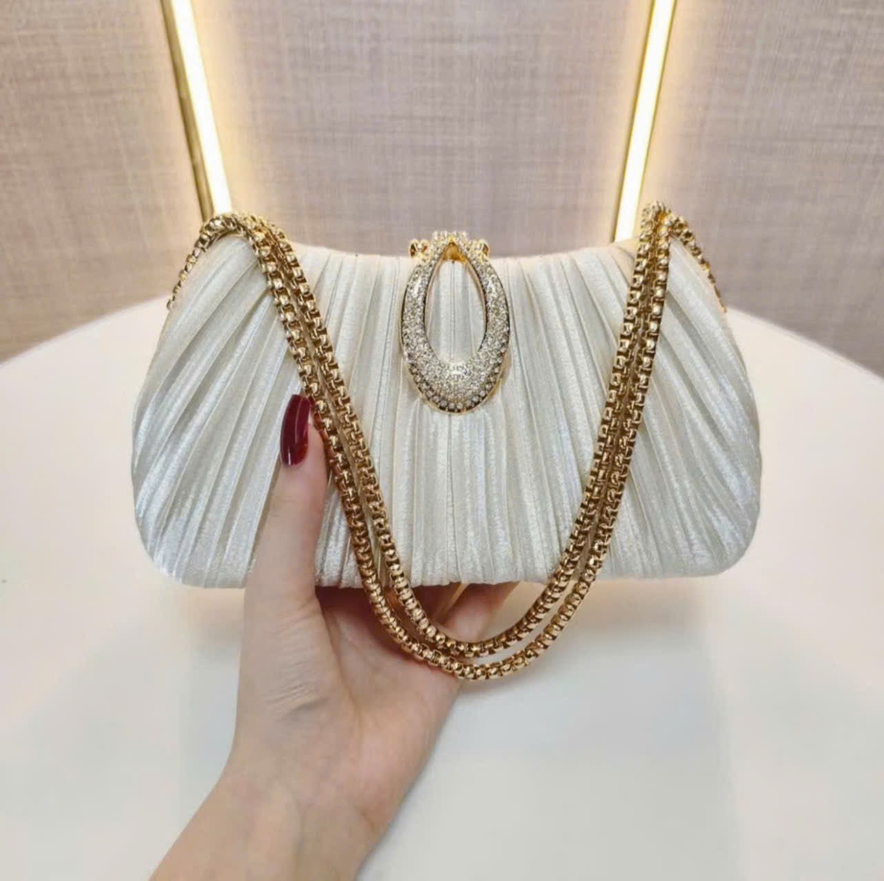 Premium women's party handbag featuring a pleated design and sparkling stone embellishments.