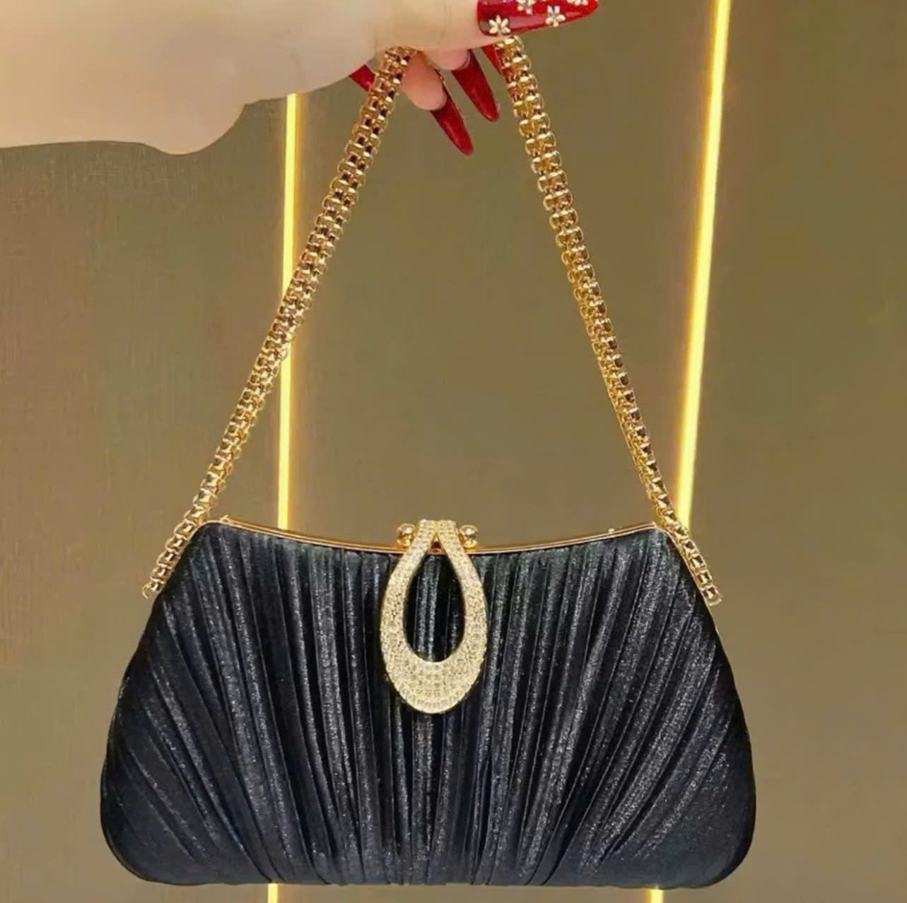 Premium women's party handbag featuring a pleated design and sparkling stone embellishments.