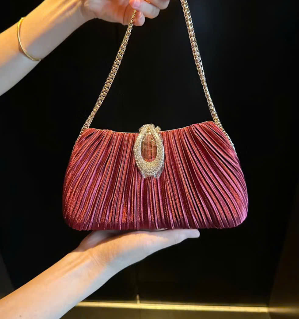 Premium women's party handbag featuring a pleated design and sparkling stone embellishments.