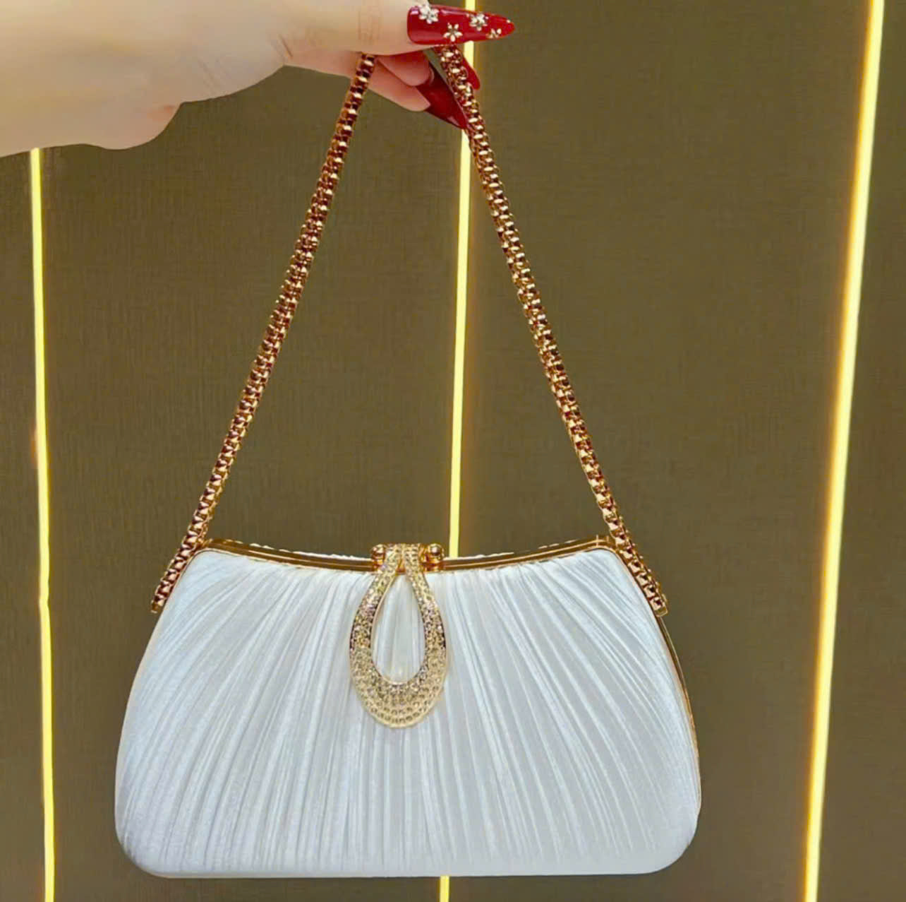 Premium women's party handbag featuring a pleated design and sparkling stone embellishments.