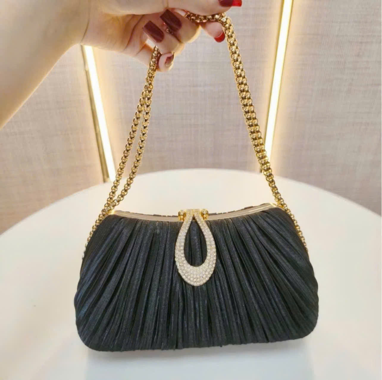 Premium women's party handbag featuring a pleated design and sparkling stone embellishments.